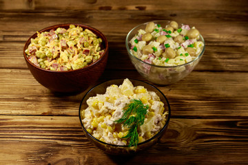 Set of festive mayonnaise salads on wooden table