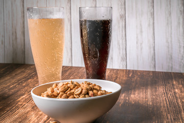 Two bear and a bowl of peanots  on a bar top