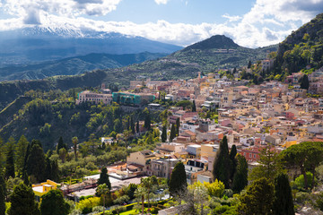 Fototapeta na wymiar Etna volcano and Taormina town aerial panoramic view. Roofs of a lot of buldings. Sicily island, Italy. 