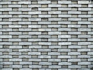 mur de briques grises rectangulaires avec reliefs apparents