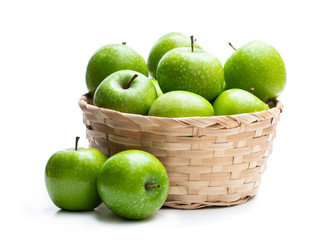 Ripe green apples in wicker basket isolated on white