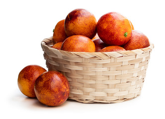 Ripe red oranges in wicker basket isolated on white