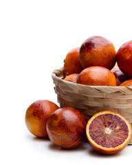 Ripe red oranges in wicker basket isolated on white