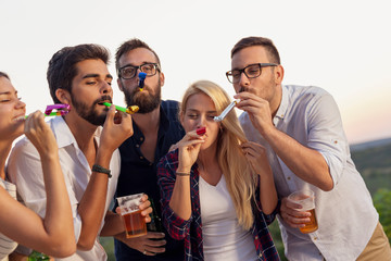 Friends blowing party whistles