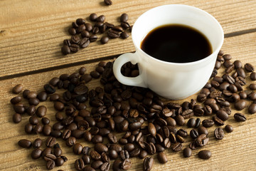 cup of coffee and beans on wooden table
