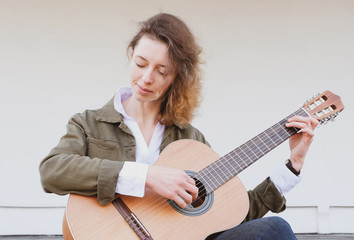 Portrait of a beautiful young woman with a guitar