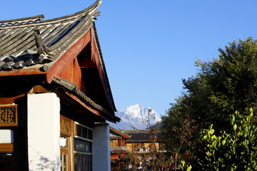Houses in the historic village of Baisha with the mountains in the background, Lijiang, Yunnan, China