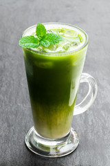 Homemade layered iced matcha latte tea with almond milk isolated on the table