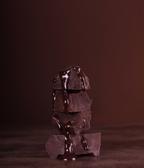 Chunks of chocolate folded pyramid of molten chocolate over dark