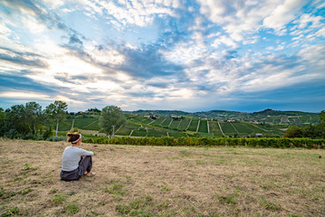 Fototapeta na wymiar portrait of young brunette in the vineyards area of wine region ready for the harvest, langhe, Piedmont, Italy