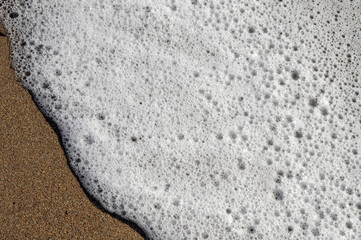 Sea foam on the sand
