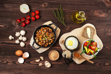 Vegetarian food. Fried mushrooms and egg in cast iron pan. Ingredients for rustic breakfast on...