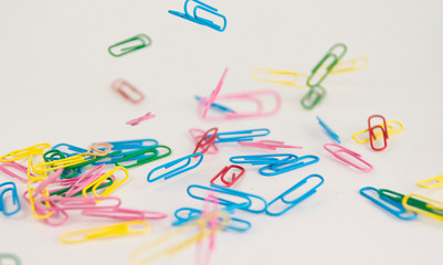 falling colorful paper clips on white background