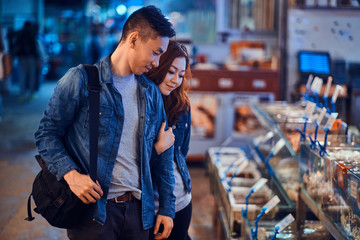 Romantic asian couple looking for something special at seafood chainese market