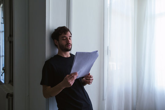 Young man reading script at home.
