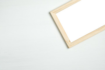 Rectangular wooden frame on a white wooden background.