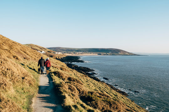Couple walking the footpath from Baggy Point to Croyde Bay. Devon, UK.