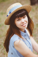 Young woman in straw boater hat smile in summer outdoors, fashion and style