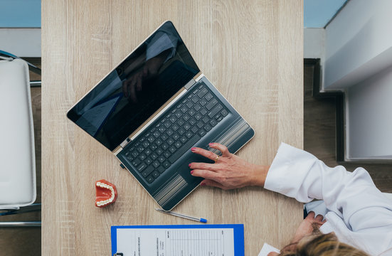 Dentist woman working on small laptop