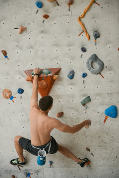 Sportive man on climbing wall