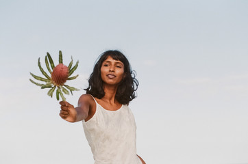 Beautiful Woman with flowers at the beach