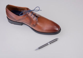 business shoe brown with ballpoint pen