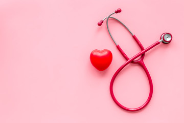 stethoscope and heart for diagnostic and cure of heart disease on pink background top view mockup