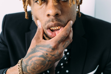 Tattooed man with shiny golden grillz