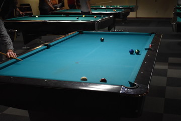 Player around the pool table getting ready for his shot