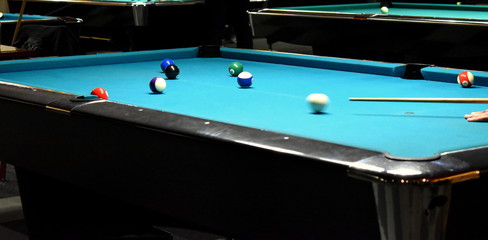 Player around the pool table getting ready for his shot