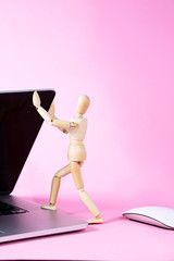 Laptop. Wooden mannequin opens the laptop. Wooden mannequin. Wooden man.