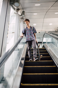 Young skater using escalator stairs downtown