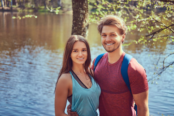 Obraz premium Group of young friends hiking through the forest with bikes on a beautiful summer day