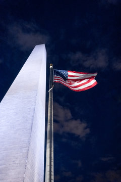 Washington Monument a radiant bright white reaching high into sky with American Flag