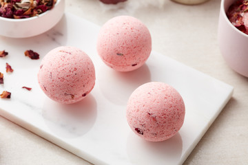 Three bath bombs with rose petals.