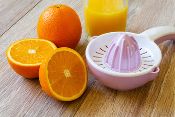two oranges, reamer and juice