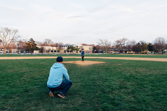 father and son on a baseball field playing catch