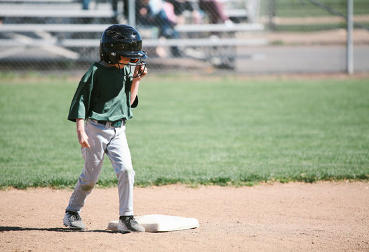 young female ballplayer readies herself at second base to run