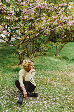 Woman sitting under blooming tree