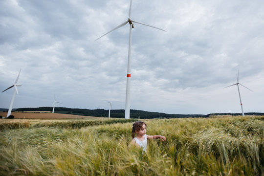 Little girl nder the wind turbine