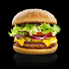 Delicious burger containing cheese, bacon, onion, cucumbers, tomatoes and lettuce, isolated on black background