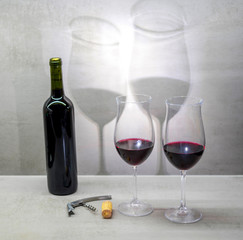 Glasses of red wine cast shadow on gray background