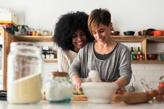 Two beautiful girls cooking in them home.