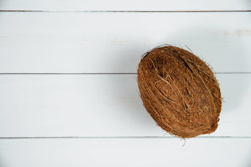 Coconut on a white wooden table. Coconuts lie on the counter, the concept of drinking milk and coconut water. Using exotic fruits.