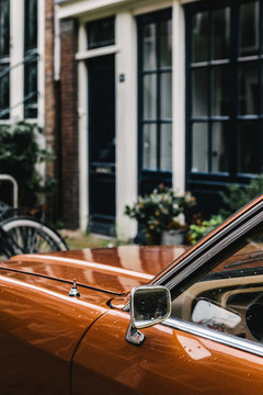 Old car parked in front of house wall