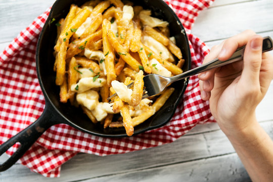 Overhead Of Person Eating Poutine