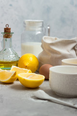 Ingredients for making cake - flour, eggs, milk or buttermilk, olive oil, sugar, lemon, baking powder. Food background. Bake sweet cake dessert concept. Copy space.