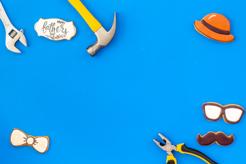 bow tie, moustache, glasses, hat and instruments for rapair for Happy Father Day on blue background top view mokeup
