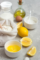 Ingredients for making cake - flour, eggs, milk or buttermilk, olive oil, sugar, lemon, baking powder. Food background. Bake sweet cake dessert concept. Copy space.