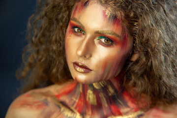 portrait of curly girl with art conceptual makeup and dark background